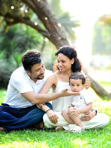 A warm, sun-drenched family portrait taken during an outdoor session in a local park. Natural light and a relaxed setting allow for authentic interactions, perfect for capturing the free-spirited nature of your family story.