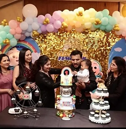A family celebrating their child's first birthday with our Cocomelon dessert table.