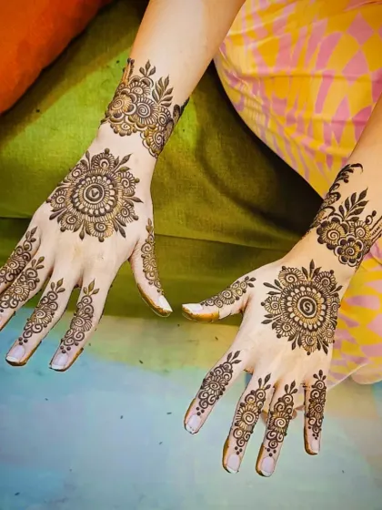 A beautiful back-of-hand design featuring a large mandala on each hand, with delicate patterns extending to the fingers.