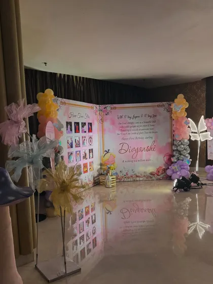 A wide view of the butterfly themed stage, featuring a large storybook style backdrop with a photo collage and message.