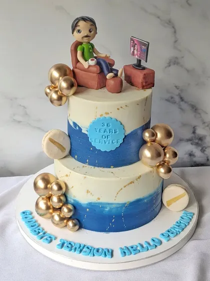 A fun and stylish two-tier retirement cake with the message "Goodbye Tension Hello Pension." The design shows a figurine relaxing in a chair, perfectly capturing the feeling of starting a new, relaxed chapter in life.