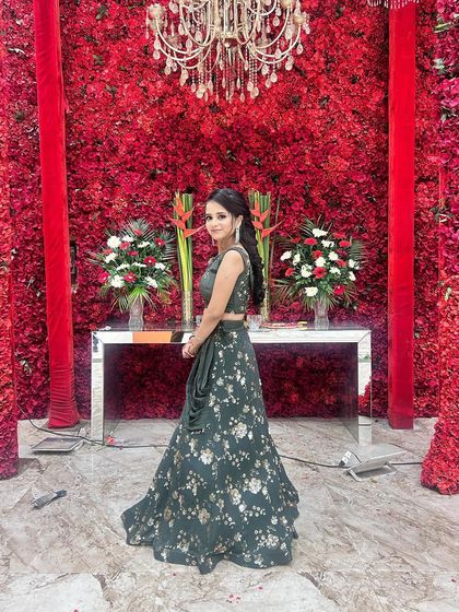 Our client looking graceful and elegant in a green floral lehenga. This outfit is a perfect choice for a wedding guest who wants to look stylish and sophisticated.