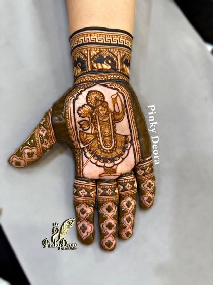 For a devotee of Shreenath Ji, this Karwa Chauth mehndi is a blessing. The central figure is drawn with devotion, surrounded by traditional patterns. I teach how to create such spiritually significant designs.