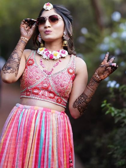 A stylish bride posing with a peace sign, her mehandi looking fabulous.