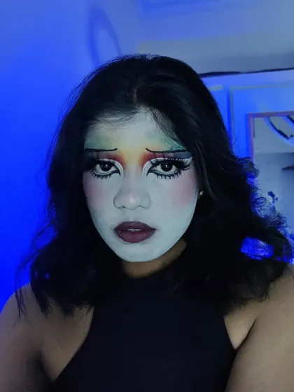 The same clown makeup under blue lighting, which completely changes the mood and makes it feel more theatrical.