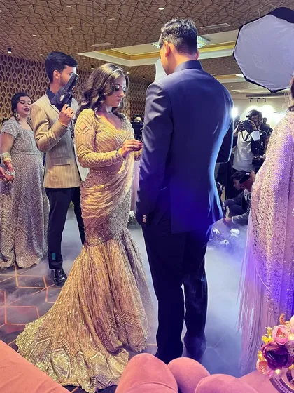 A behind-the-scenes shot of the couple during their ring ceremony. The dramatic lighting and smoke effect add to the magic of the moment.