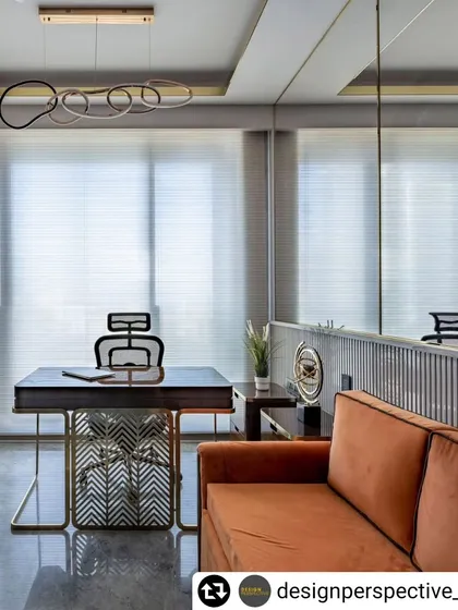 The home office within the 'Fifty Two' luxury apartment, featuring a bespoke desk with a patterned metal base and a modern ring-shaped light fixture.