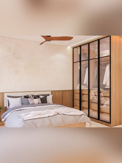 A view of a master bedroom featuring a modern glass and wood wardrobe. The transparent doors make the room feel larger and allow for a curated display of clothing, blending storage seamlessly with the room's aesthetic.