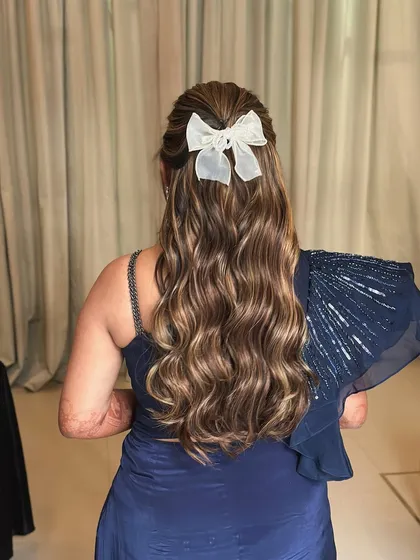 Bows and waves for a Bollywood-themed night. This is such a fun and feminine hairstyle, with soft waves and a cute white bow to top it off.