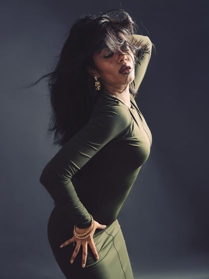 A high-energy pose with dramatic hair movement, creating a sense of wild elegance.