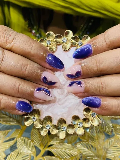 A unique design using purple cat eye polish to create a reverse French or half-moon effect on a neutral base.