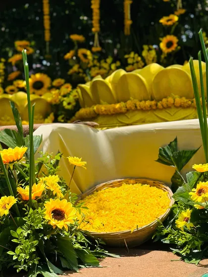 Detail shot of the Haldi seating area, featuring a custom yellow lotus-shaped seat and a basket filled with fresh marigold petals for the ceremony.