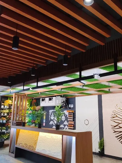 A creative ceiling design combining wooden baffle ceilings with artificial grass panels, showing how you can bring the outdoors in.