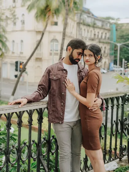 An intimate and stylish portrait against a city backdrop. Pragati and Swapnil share a quiet moment on a balcony overlooking the streets of Mumbai.