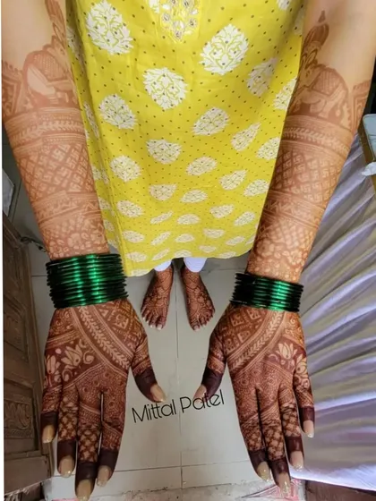This photo showcases the beautiful, fresh stain of a full bridal mehndi on both hands and feet. The designs are coordinated, creating a harmonious and complete look.