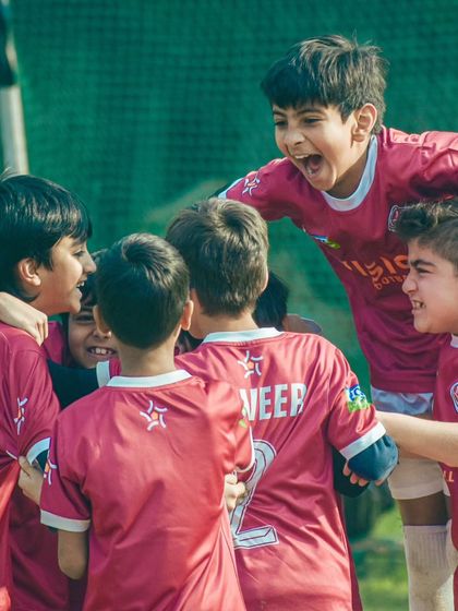 The raw passion of the game. A candid shot of our players celebrating a goal with pure, uncontainable joy.