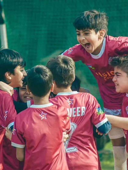 The raw passion of the game. A candid shot of our players celebrating a goal with pure, uncontainable joy.