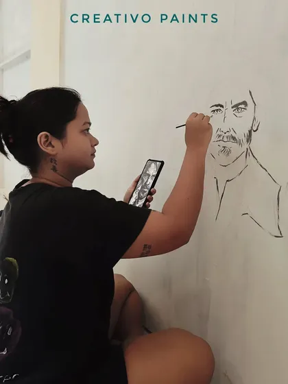This is where it all begins. I start by sketching the entire design directly onto the wall, using a reference on my phone to ensure every character is perfectly placed.