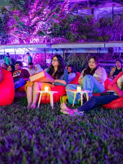 Guests engrossed in the movie, with candlelight and purple ambient lighting creating a cozy and romantic atmosphere.