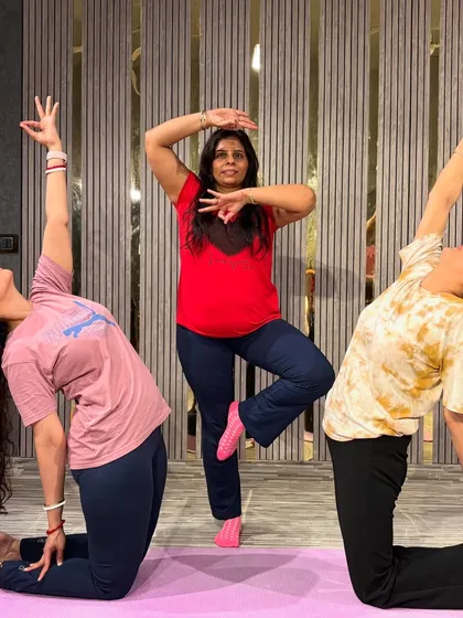Finding balance and focus in a group setting. This photo captures a beautiful moment from a yoga class, with students holding different asanas like Tree Pose (Vrikshasana) and a kneeling backbend.