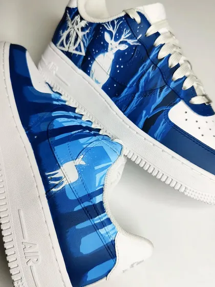 A pair of custom Nike Air Force 1s for a Harry Potter fan. This design is inspired by the Deathly Hallows, featuring Snape's Patronus, a stag, in a forbidden forest scene.