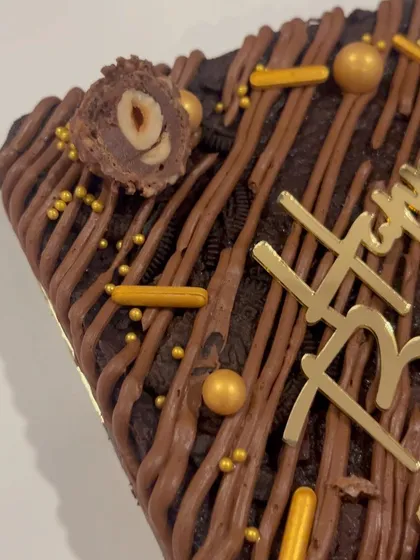 A detailed shot of the Ferrero Rocher brownie cake, showing the rich texture and toppings. It's a chocolate lover's dream come true.