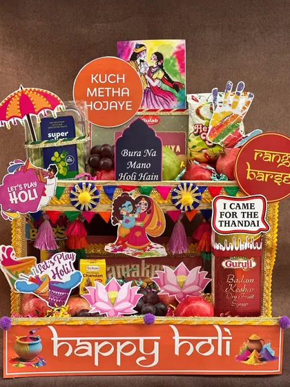 Bringing a *rangeen* blast to your Holi celebrations! This hamper is designed to look like a vibrant street stall, packed with fresh fruits, thandai, gujia, and fun props like water guns and colors to get the party started.