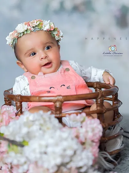 This studio setup combines rustic props with soft, delicate florals to create a beautiful and happy portrait for a baby girl.