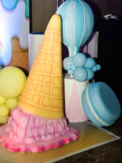 A giant prop of a dropped ice cream cone adds a playful and whimsical touch to the Candyland decor.