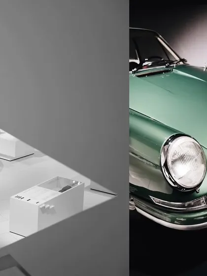 An artistic composition from the Porsche museum, playing with angles and reflections. The image contrasts the futuristic lines of a concept car with the classic shape of a green Porsche 911.