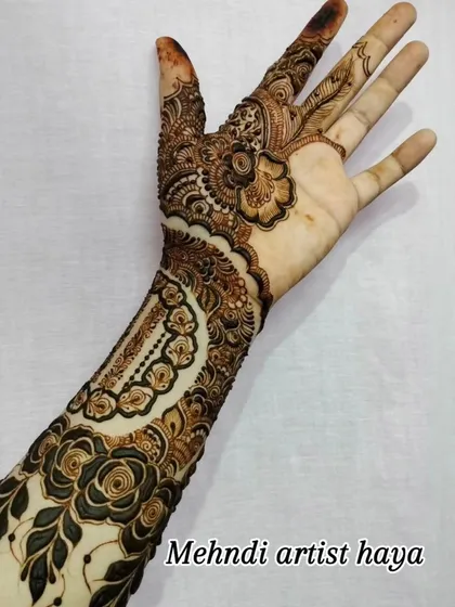 A view of the palm side of the cuff design, showing how the pattern continues with intricate details on the fingers and palm.