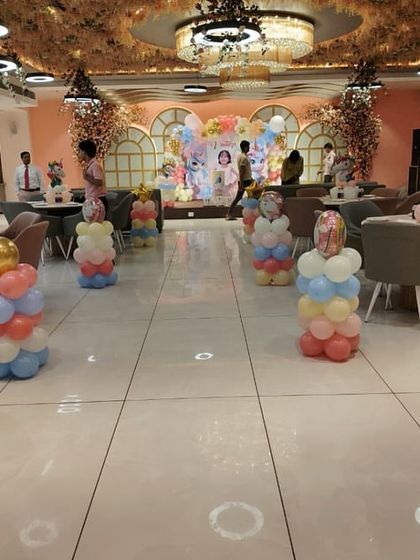 For larger venues like banquet halls, I can create expansive themed decorations. This unicorn party features multiple balloon pillars lining the walkway to the main stage, creating an impressive entrance.