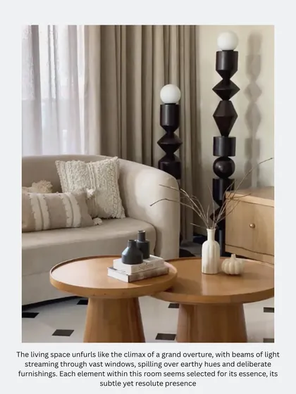 The living space unfolds with beams of light from vast windows, highlighting the earthy hues and deliberate furnishings. The totem-like floor lamps add a sculptural, modern element.