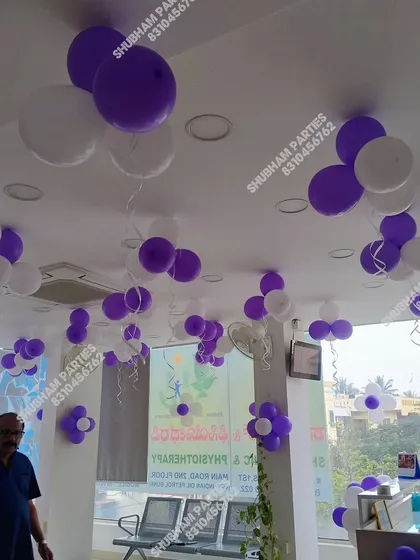Purple and white balloons decorating the ceiling of a physiotherapy clinic for an event.