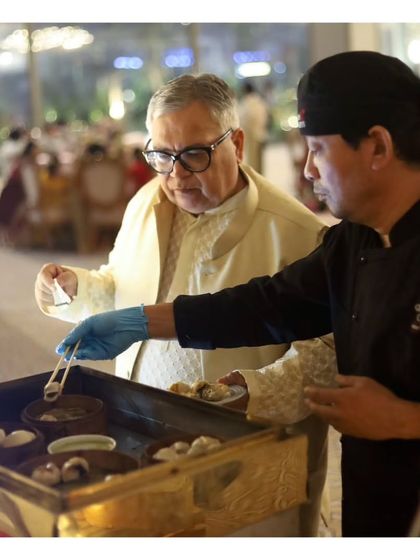 A guest is served freshly made dim sum by our chef. This interaction highlights the appeal of our live stations, where guests can see the quality and care that goes into their food.