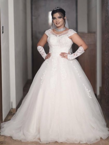 For a classic white wedding, I offer beautiful Christian wedding gowns for rent. This elegant ball gown features a timeless silhouette with delicate lace details on the bodice and matching lace gloves for a complete, traditional look.