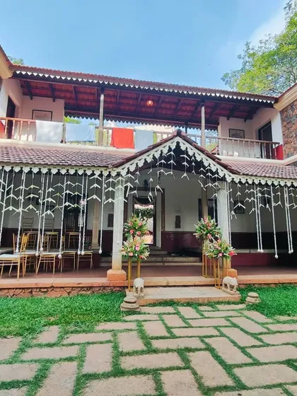 The entrance to the traditional wedding venue, decorated with hanging strings of white flowers and elegant floral bouquets.