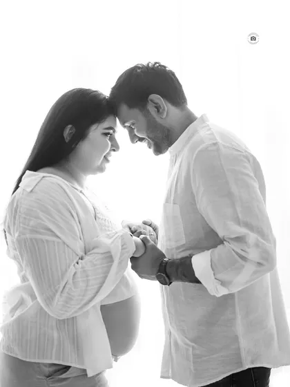 An intimate black and white close-up of a couple holding hands and touching foreheads, capturing a moment of pure connection.