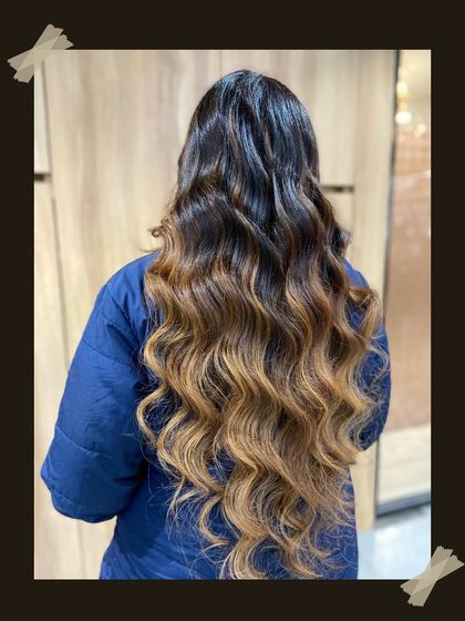 A full view of a stunning balayage with perfectly crafted waves. This look showcases the length and health of the hair, enhanced by our coloring and styling expertise.