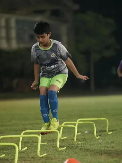 A young player working on his agility and footwork over hurdles. These fundamental drills build the foundation for advanced skills.