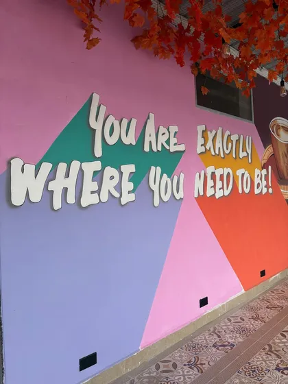 A 3D acrylic quote, "You Are Exactly Where You Need To Be!", designed to create a positive and welcoming vibe in the cafe's seating area.