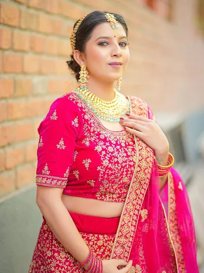 A model in a vibrant pink bridal lehenga, perfect for a North Indian wedding look.