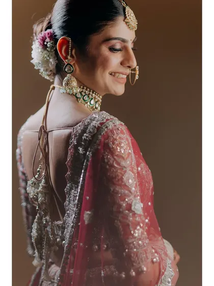 A beautiful close-up of the bride's happy smile. This shot captures her from behind, highlighting the details of her hair, jewelry, and the radiant joy on her face.
