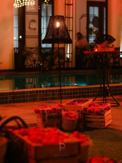 A poolside setup for "Call Me Bae" that balances rustic charm with a touch of luxury. The warm glow from the floor lamp, combined with crates of apples, created a relaxed yet elegant atmosphere by the water.