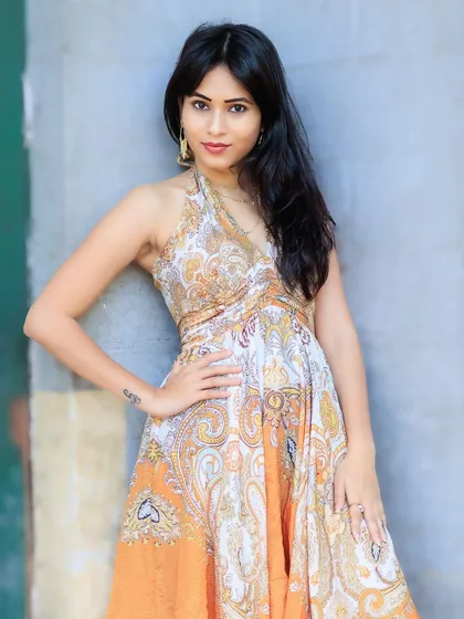 A confident and stylish pose against a simple wall. The vibrant colors of the dress are the star of the show.