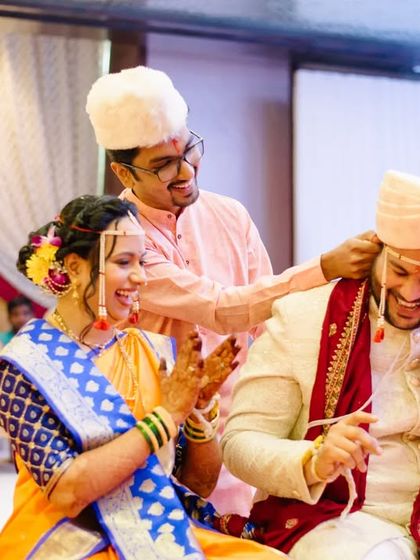 A playful moment during the wedding rituals, with family members sharing a laugh with the happy couple.