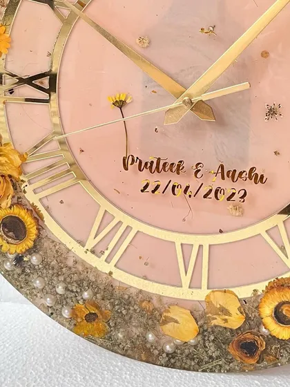 A close-up of a 16-inch wall clock I created for an event planner's clients. The preserved sunflowers and baby's breath on a soft pink background are just so cheerful.