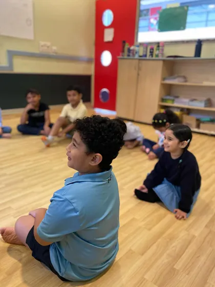 Students sitting attentively during a storytelling session. Listening is a critical skill in theatre, and we practice it in every class.