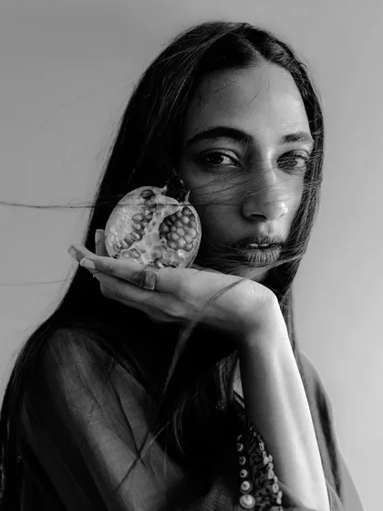An editorial portrait of Naina for a campaign with fashion label Swatti Kapoor. This close-up shot on film highlights the subject's expression and the artistic use of a prop to create a compelling image for the brand.