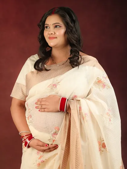 The elegance of a simple white floral saree is undeniable. This portrait is soft, serene, and captures the quiet joy of awaiting a new arrival.